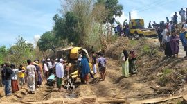 Warga membangu mengevakuasi excavator dan operator yang terhimpit Dusun Cekonce, Desa Sana Tengah, Kecamatan Pasean.
