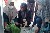 Petugas Puskesmas Pamolokan saat mengecek kondisi bayi yang ditemukan warga di Masjid Al Kautsar, Desa Pamolokan, Kecamatan Kota Sumenep.