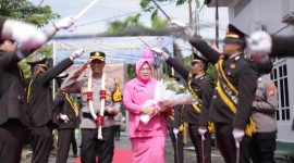 Kapolres Sampang AKBP Hartono bersama Ny. Daru Hartono melewati payung pora saat tiba di Mapolres Sampang.