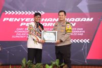 Bupati Sumenep Achmad Fauzi Wongsojudo menyerahkan penghargaan kepada Kapolres Sumenep AKBP Henri Noveri Santoso yang dinilai sukses menjadi inisiator ketahanan pangan dalam rangka mendukung Program Asta Cita Presiden Prabowo.