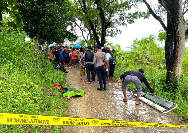 Polisi mengevakuasi jenazah Y yang tergeletak di Jalan Dusun Melkok Timur, Desa Bapelle, Kecamatan Robatal, Kabupaten Sampang. (FOTO: POLRES SAMPANG FOR KLIKMADURA) 