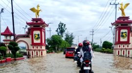 Pengendara motor berhati-hati melewati genangan air di Jalan Trunojoyo, tepatnya di Desa Patean, Kecamatan Batuan, Sumenep. (FOTO: ZAINURRAHMAN / KLIKMADURA).