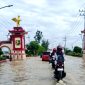 Pengendara motor berhati-hati melewati genangan air di Jalan Trunojoyo, tepatnya di Desa Patean, Kecamatan Batuan, Sumenep. (FOTO: ZAINURRAHMAN / KLIKMADURA).