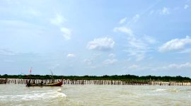 Perahu nelayan berada di sekitar bambu-bambu yang ditancapkan di Pantai Jumiang, Desa Tanjung, Kecamatan Pademawu, Pamekasan. (MOH. IQBALUL KHAVEI MZ / KLIKMADURA)