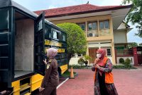 Oknum agen pegadaian, Hozizah hendak masuk mobil tahanan usai sidang di PN Pamekasan, Kamis (13/2/2025). (MOH. IQBALUL KHAVEI MZ / KLIKMADURA)