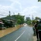 Polisi mengatur lalu lintas di Jalan Imam Bonjol yang mulai dikepung banjir. (SUPRIYANTO / KLIKMADURA)