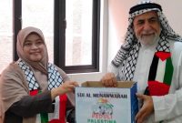 Kepala SDI Al Munawwarah Dedeh Rosidah, S.Pd menyerahkan donasi untuk Palestina kepada Syeikh Omar Ied Abdel Qodir.