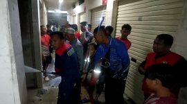 Petugas pemadam kebakaran berjibaku menjinakkan api yang melalap salah satu kios di Pasar Kolpajung Pamekasan.