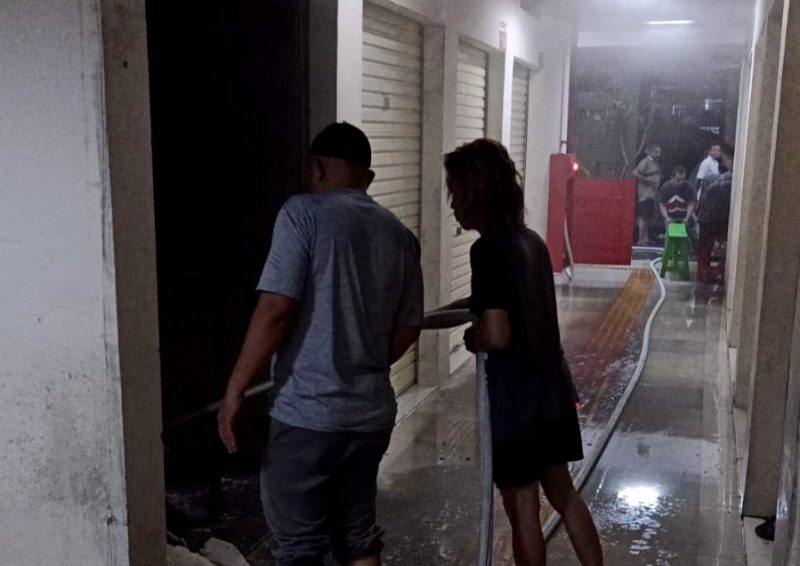 Warga membantu tim pemadam kebakaran menjinakkan api yang melalap salah satu kios di Pasar Kolpajung.