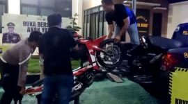 Anggota Polsek Sokobanah menurunkan motor yang terlibat aksi balap liar.