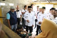 Bupati Pamekasan KH. Kholilurrahman saat mengunjungi Slamet, warga Kelurahan Jungcangcang, Kecamatan Pamekasan.