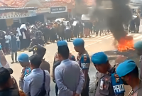 Ribuan warga membakar ban bekas saat menggelar aksi demonstrasi di depan Kantor Kecamatan Banyuates, Sampang, Madura, Jawa Timur.
