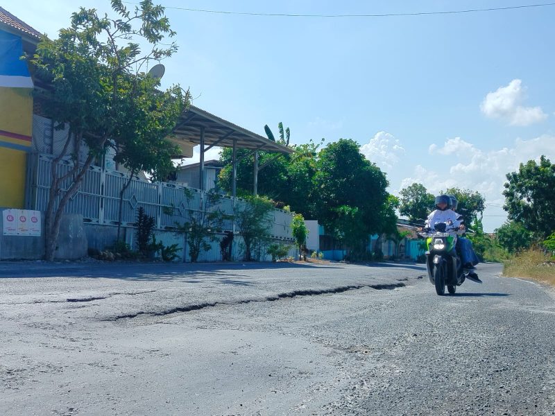 RUSAK: Pengendara melintas di Jalan Raya Panglegur, Kecamatan Tlanakan, Pamekasan yang kondisinya rusak. (DOK. KLIKMADURA)