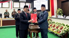 Ketua DPRD Pamekasan Ali Masykur (kanan) menyerahkan dokumen keputusan DPRD terhadap Rekomendasi Perbaikan Penyelenggaraan Pemerintahan Daerah kepada Bupati Pamekasan KH. Kholilurrahman. (MOH. IQBALUL KHAVEI MZ / KLIKMADURA)