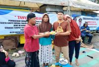Ketua Paguyuban PKL dan UMKM Berteman, Nur Faisal memberikan tumpeng kepada salah satu PKL usai tasyakuran. (KLIKMADURA)