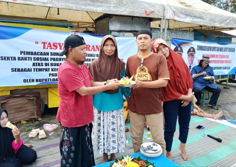 Ketua Paguyuban PKL dan UMKM Berteman, Nur Faisal memberikan tumpeng kepada salah satu PKL usai tasyakuran. (KLIKMADURA)