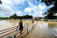 Warga berada di sungai dengan volume air penuh tepatnya di Kelurahan Patemon, Kecamatan Kota Pamekasan. (MOH. IQBALUL KHAVEI MZ / KLIKMADURA)