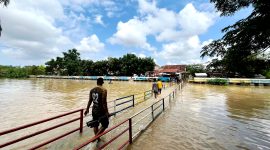 Warga berada di sungai dengan volume air penuh tepatnya di Kelurahan Patemon, Kecamatan Kota Pamekasan. (MOH. IQBALUL KHAVEI MZ / KLIKMADURA)