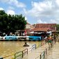 Warga Kelurahan Patemon, Kecamatan Kota Pamekasan bersiaga di dekat sungai dengan kondisi volume air penuh. (MOH. IQBALUL KHAVEI MZ / KLIKMADURA)