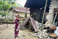 Qurrotul Aini, warga Desa Samiran, Kecamatan Proppo menunjukkan dapur miliknya yang ambruk akibat hujan dan angin kencang. (MOH. IQBALUL KHAVEI MZ / KLIKMADURA)