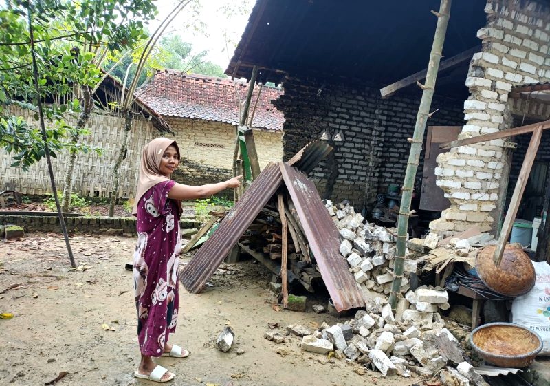 Qurrotul Aini, warga Desa Samiran, Kecamatan Proppo menunjukkan dapur miliknya yang ambruk akibat hujan dan angin kencang. (MOH. IQBALUL KHAVEI MZ / KLIKMADURA)