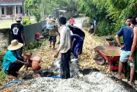 Warga Desa Plampaan, Kecamatan Camplong, Sampang memperbaiki poros jalan desa yang puluhan tahun dibiarkan rusak. (MUKSIN IKSAN / KLIKMADURA)