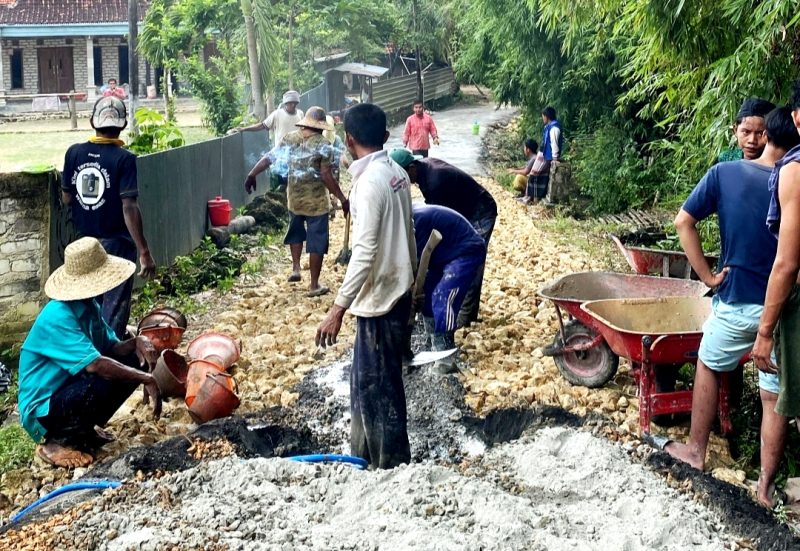 Warga Desa Plampaan, Kecamatan Camplong, Sampang memperbaiki poros jalan desa yang puluhan tahun dibiarkan rusak. (MUKSIN IKSAN / KLIKMADURA)