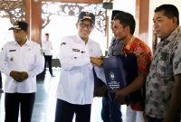 SIMBOLIS: Bupati Pamekasan Dr. KH. Kholilurrahman memberikan jerigen kepada nelayan di Mandhapa Agung Ronggosukowati (PROKOPIM PAMEKASAN UNTUK KLIK MADURA).
