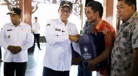 SIMBOLIS: Bupati Pamekasan Dr. KH. Kholilurrahman memberikan jerigen kepada nelayan di Mandhapa Agung Ronggosukowati (PROKOPIM PAMEKASAN UNTUK KLIK MADURA).