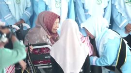 Nyai Hj Halimatus Sa'diyah mengalungkan selempang tanda kelulusan santri. (Al-Amien TV)
