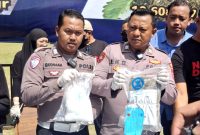 Dua personel kepolisian menunjukkan barang bukti sabu sebelum pemusnahan di Pendopo Agung Ronggosukowati Pamekasan. (MOH. IQBALUL KHAVEI MZ / KLIKMADURA)