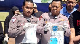Dua personel kepolisian menunjukkan barang bukti sabu sebelum pemusnahan di Pendopo Agung Ronggosukowati Pamekasan. (MOH. IQBALUL KHAVEI MZ / KLIKMADURA)