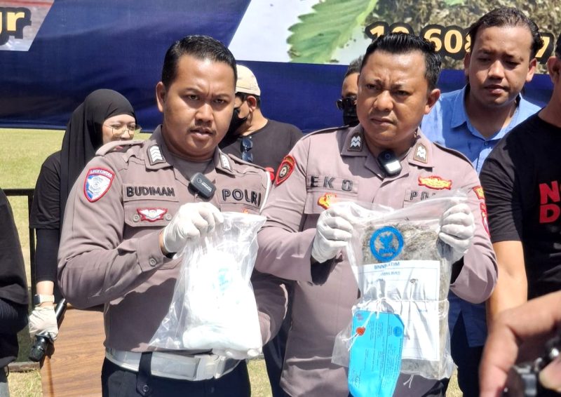 Dua personel kepolisian menunjukkan barang bukti sabu sebelum pemusnahan di Pendopo Agung Ronggosukowati Pamekasan. (MOH. IQBALUL KHAVEI MZ / KLIKMADURA)