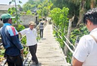 PERLU PERBAIKAN: Petugas Dinas PUPR Pamekasan melakukan monitoring pemeliharaan jembatan di Kelurahan Barurambat Timur, Pamekasan, beberapa waktu lalu. (DINAS PUPR PAMEKASAN UNTUK KLIK MADURA).