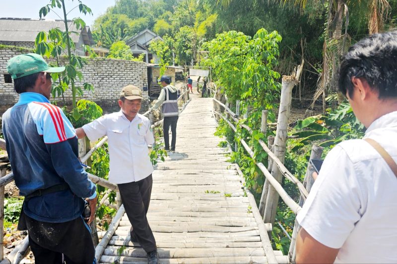 PERLU PERBAIKAN: Petugas Dinas PUPR Pamekasan melakukan monitoring pemeliharaan jembatan di Kelurahan Barurambat Timur, Pamekasan, beberapa waktu lalu. (DINAS PUPR PAMEKASAN UNTUK KLIK MADURA).