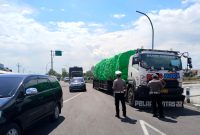 Anggota Satlantas Polres Sampang menyetop truk dengan muatan besar di Jalan Lingkar Selatan (JLS). (IBNU ANSORI / KLIKMADURA)