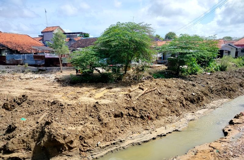 TERIK: Warga berada di sekitar sungai di Jalan Amin Jakfar yang sudah dilakukan pengerukan. (LAILIYATUN NURIYAH/KLIK MADURA).