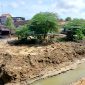 TERIK: Warga berada di sekitar sungai di Jalan Amin Jakfar yang sudah dilakukan pengerukan. (LAILIYATUN NURIYAH/KLIK MADURA).