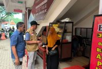 Kepala Pasar Kolpajung, Slamet Efendi berbincang dengan salah satu pedagang. (MOH. IQBALUL KHAVEI MZ / KLIKMADURA)