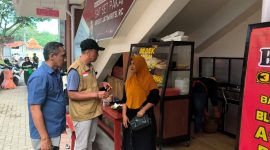 Kepala Pasar Kolpajung, Slamet Efendi berbincang dengan salah satu pedagang. (MOH. IQBALUL KHAVEI MZ / KLIKMADURA)