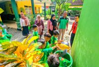 BERSIH: Siswa SDN Pakong 2 Pamekasan membuang sampah di tempat sampah. (DOK. KLIK MADURA)