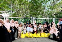 Tim Hijabi Madura foto bersama yatim dan duafa usai penyerahan santunan di area Taman Arek Lancor, Pamekasan. (SARI PURWATI / KLIKMADURA)