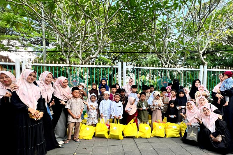 Tim Hijabi Madura foto bersama yatim dan duafa usai penyerahan santunan di area Taman Arek Lancor, Pamekasan. (SARI PURWATI / KLIKMADURA)