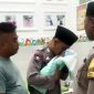 Bhabinkamtibmas Desa Ketapang Barat, Bripka Moh. Jufri mengazani bayi yang ditemukan di area persawahan Desa Ketapang Barat, Kecamatan Ketapang, Sampang. (ISTIMEWA)
