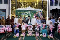 Puluhan anak yatim foto bersama usai mendapat paket sembako dari RSIA Puri Bunda Madura. (ISTIMEWA)