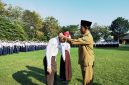 RESMI: Kepala SMPN 1 Pamekasan, Jamil menyematkan kalung tanda pengenal murid baru. (LAILIYATUN NURIYAH/KLIK MADURA).