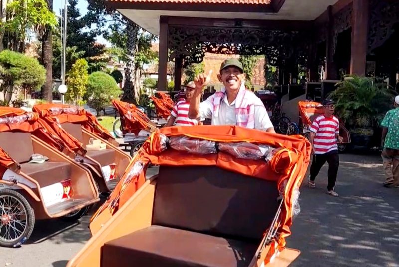 Salah satu penerima abang becak foto di atas becak listrik pemberian Presiden Prabowo Subianto di Pendopo Agung Ronggosukowati Pamekasan. (MOH. IQBALUL KHAVEI MZ / KLIKMADURA)