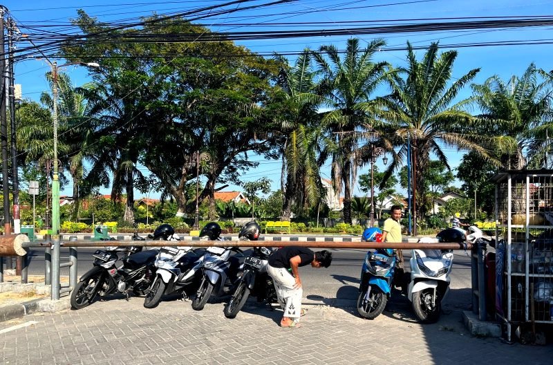 Sejumlah warga tidak bisa memasukkan kendaraan bermotor ke area eks Stasiun PJKA Pamekasan lantaran portal belum dibuka. (MOH. IQBALUL KHAVEI MZ / KLIKMADURA)