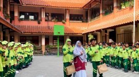 Kepala SDI Al-Munawwarah, Dedeh Rosidah, S.Pd foto bersama siswa pada peringatan Hari Anak Nasional. (LAILIYATUN NURIAH / KLIKMADURA)
