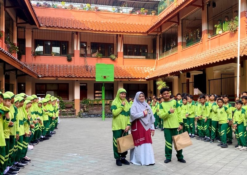 Kepala SDI Al-Munawwarah, Dedeh Rosidah, S.Pd foto bersama siswa pada peringatan Hari Anak Nasional. (LAILIYATUN NURIAH / KLIKMADURA)